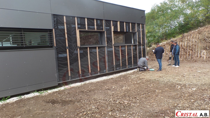 Chantier Cristal A.B. : pose de membrane Solitex et liteaux sur façade moderne avec ouvriers.