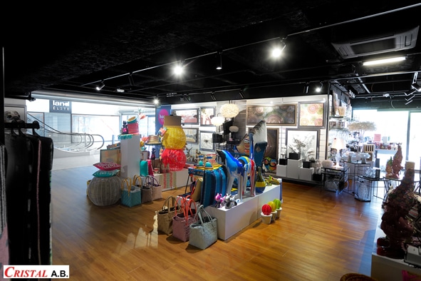 Boutique Cristal A.B. avec décoration colorée, tableaux et objets design sous un éclairage moderne.