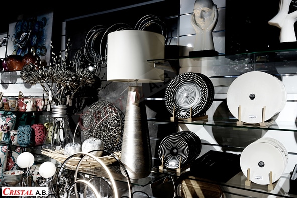 Décoration intérieure chez Cristal A.B. avec lampe design, vaisselle moderne et sculptures élégantes sur étagères.
