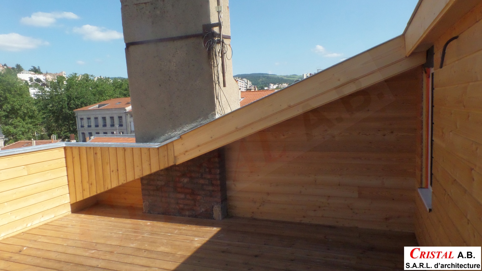 Aménagement d'une terrasse de toit en bois clair par Cristal AB Architecture, vue sur la ville sous un ciel bleu.