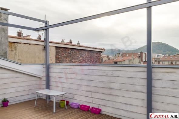 Terrasse de toit avec pergola grise, table blanche, pots de fleurs colorés et vue sur la ville par Cristal A.B.